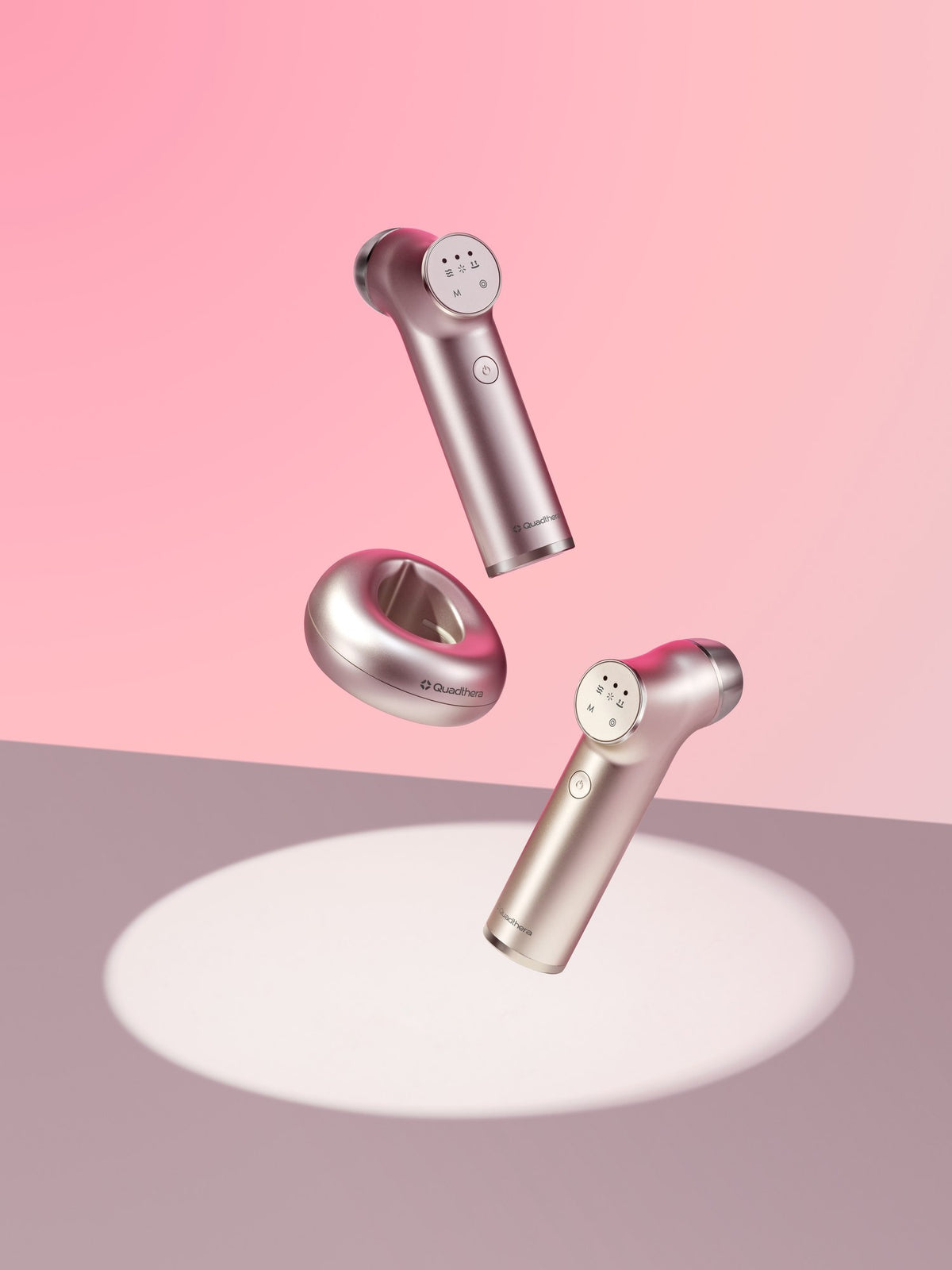 Minititan Charging Cradle floating with two Minititan devices over a spotlight on a pink backdrop (Minititan sold separately)